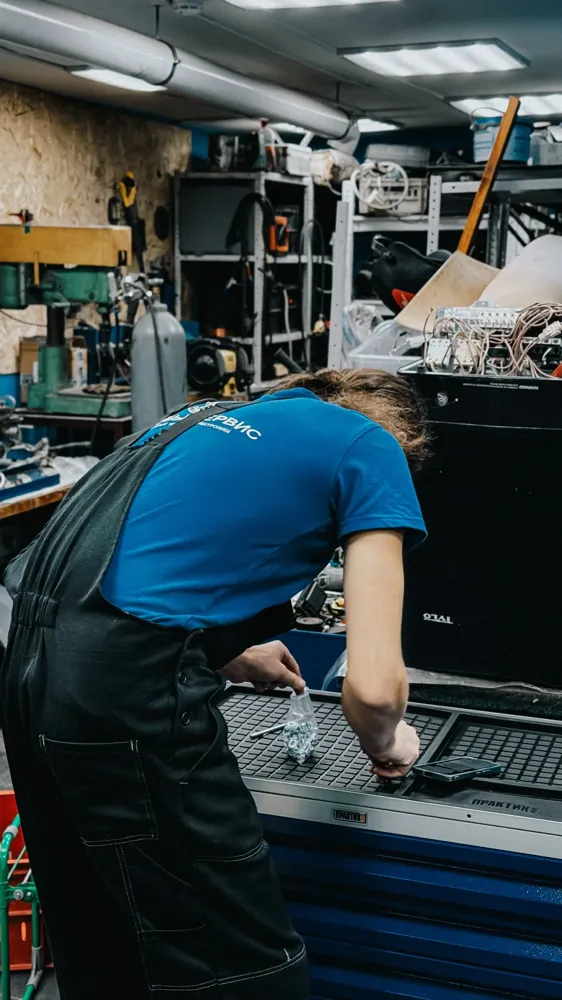 Servis teknisyeni cihazın iç kısmına eğilmiş